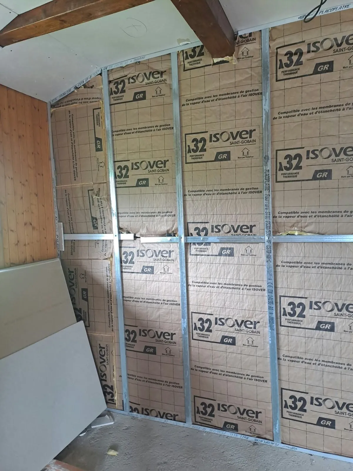 Mur en cours d'isolation, laine minérale posée entre des rails métalliques