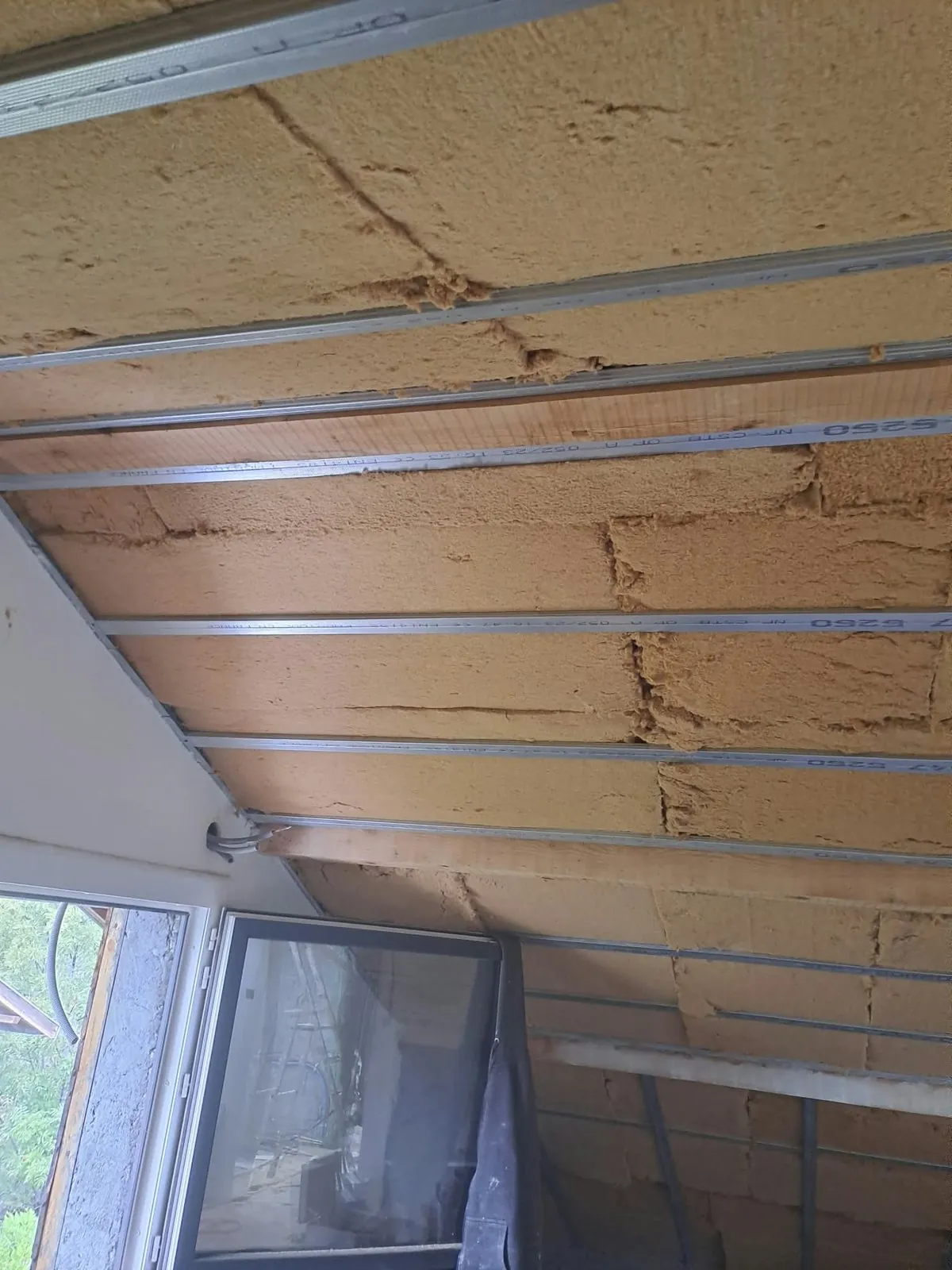 Rampant de toiture isolé, panneaux isolants fixés sous des rails métalliques